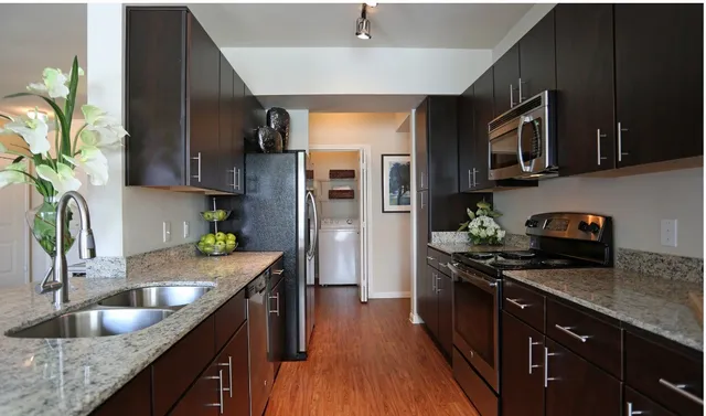 a kitchen with stainless steel appliances granite countertop a sink a stove and a refrigerator