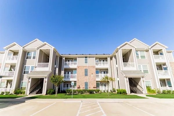a front view of a residential apartment building with a yard