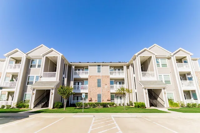 a front view of a residential apartment building with a yard
