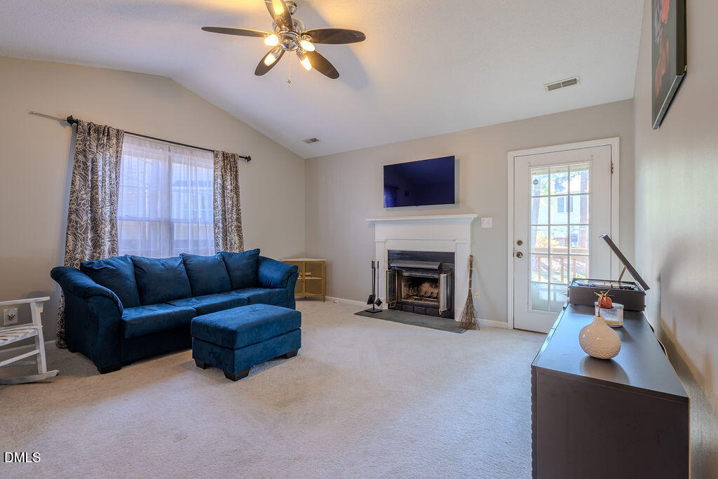 213 Bracken Court Raleigh, NC 27615 - Photo 10 of 20 a living room with furniture a fireplace and a flat screen tv