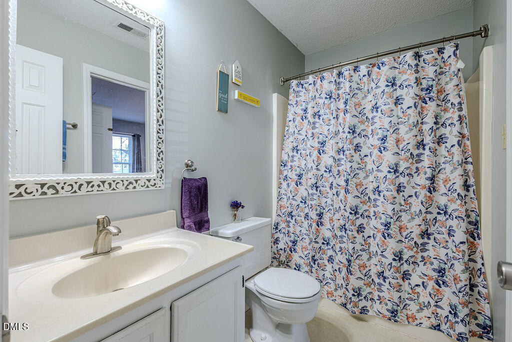 213 Bracken Court Raleigh, NC 27615 - Photo 6 of 20 a bathroom with a sink toilet and mirror
