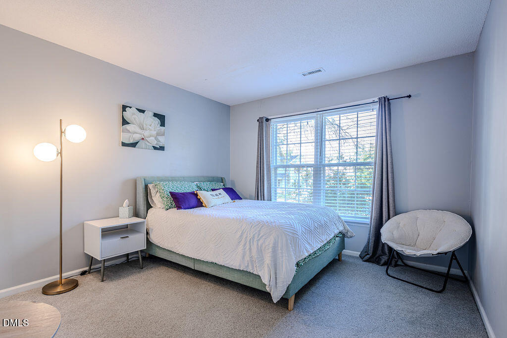 213 Bracken Court Raleigh, NC 27615 - Photo 7 of 20 a bedroom with a bed and a window