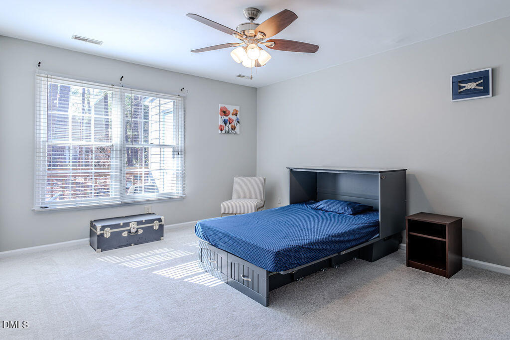 213 Bracken Court Raleigh, NC 27615 - Photo 8 of 20 a spacious bedroom with a bed and a dresser next to a window