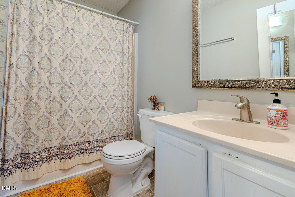 213 Bracken Court Raleigh, NC 27615 - Photo 9 of 20 a bathroom with a granite countertop sink and a toilet