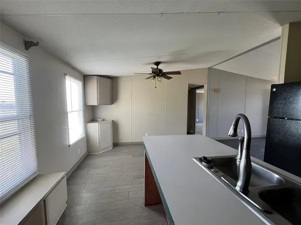 a view of a kitchen with refrigerator and windows
