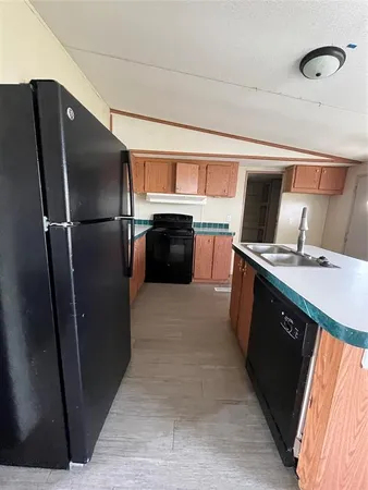 a kitchen with stainless steel appliances granite countertop a refrigerator a stove and a sink