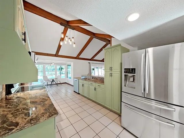 a kitchen with sink refrigerator and window