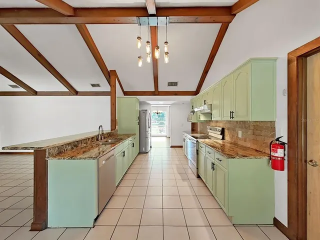 a large kitchen with stainless steel appliances granite countertop a stove and cabinets