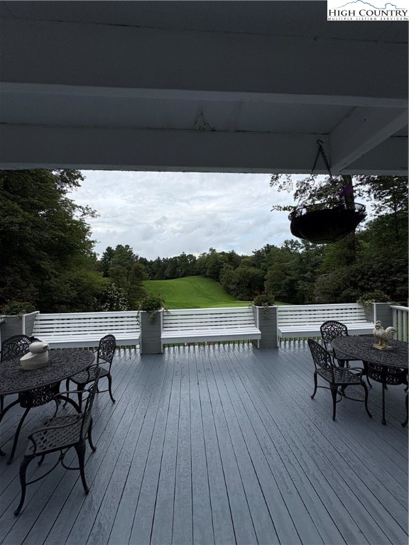 638 Ridge Road Glade Valley, NC 28627 - Photo 30 of 35 a view of a roof deck with table and chairs with wooden floor and fence