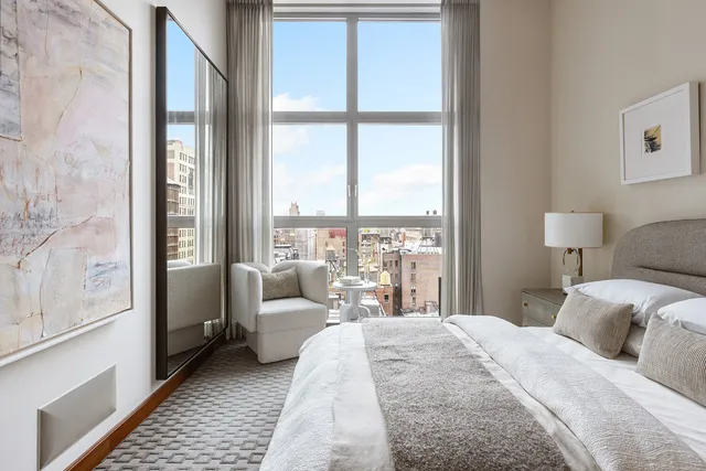a bedroom with a bed and a large window