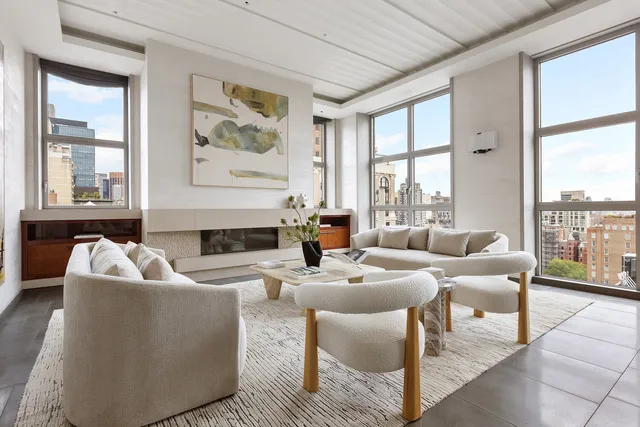 a living room with fireplace furniture and a large window