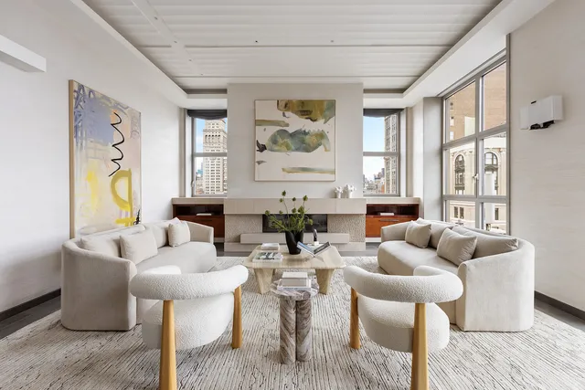 a living room with fireplace furniture and a large window