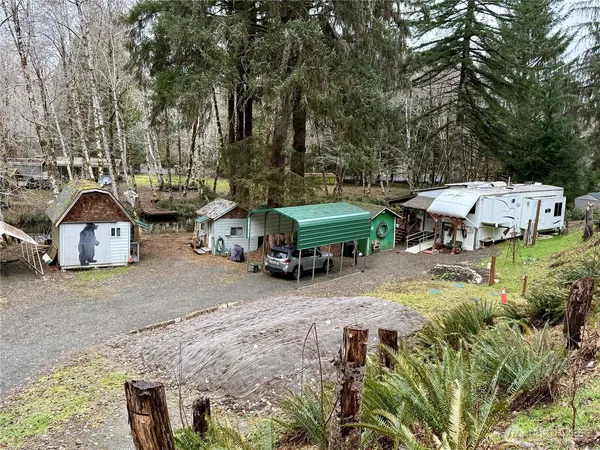 an aerial view of a house with swimming pool and large trees