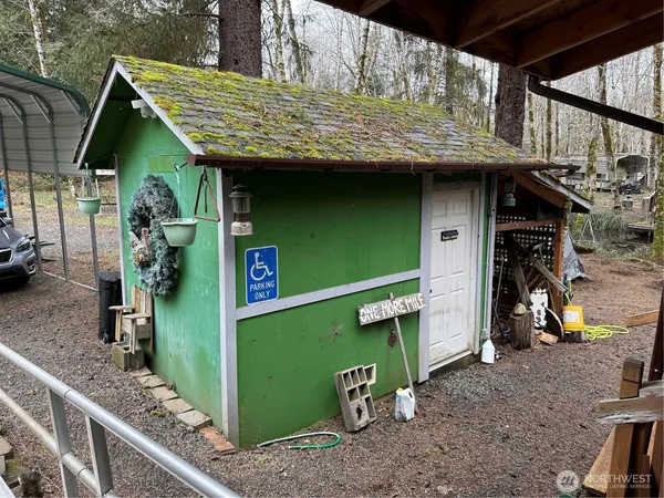 a view of a wooden house with a chairs and table in the patio