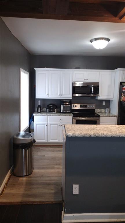 136 Hill Street Commerce, GA 30529 - Photo 17 of 27 a kitchen with kitchen island granite countertop a refrigerator and a stove top oven