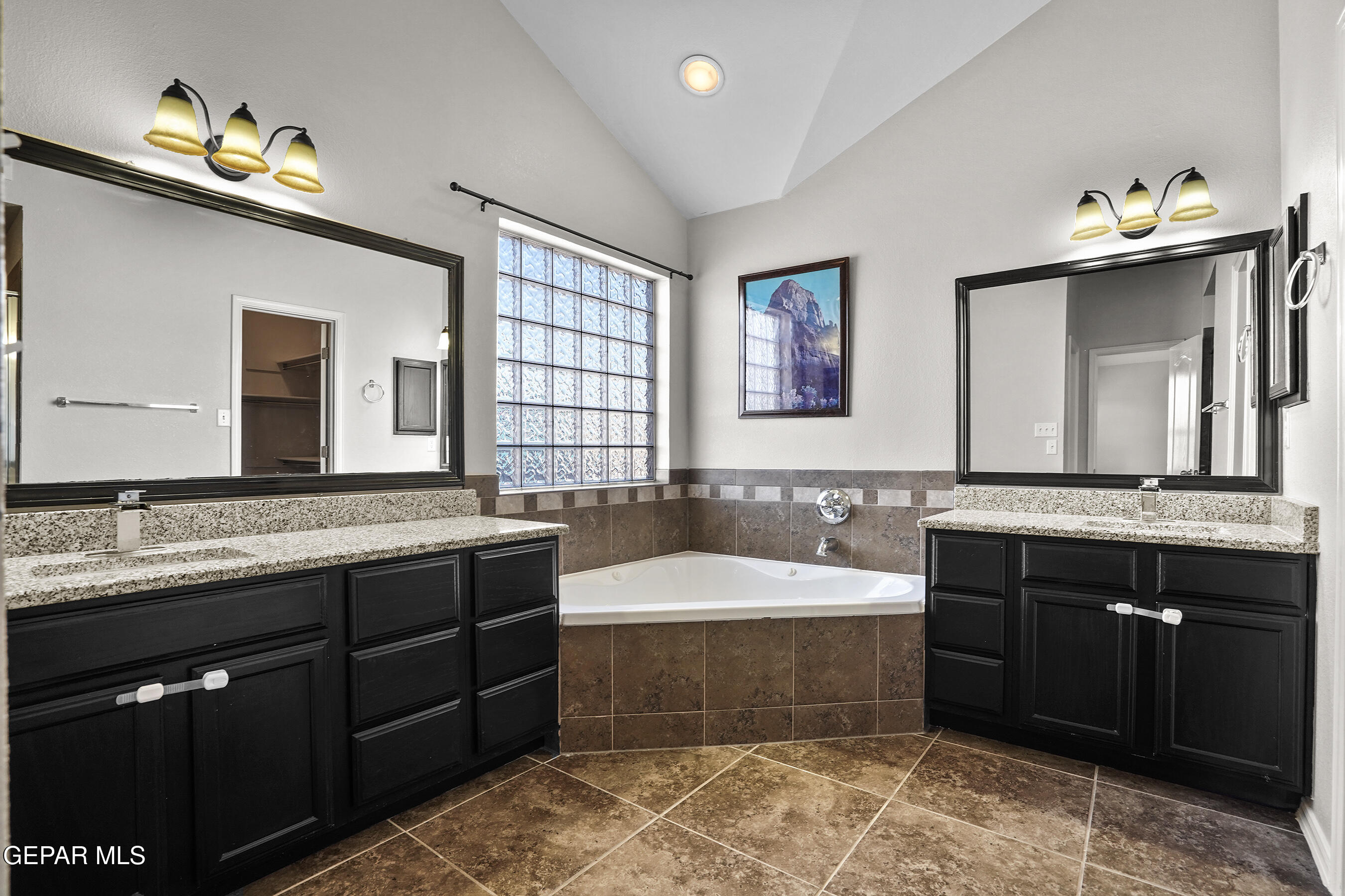 11265 Cattle Ranch Street El Paso, TX 79934 - Photo 20 of 44 a bathroom with a tub double vanity sink and a large mirror