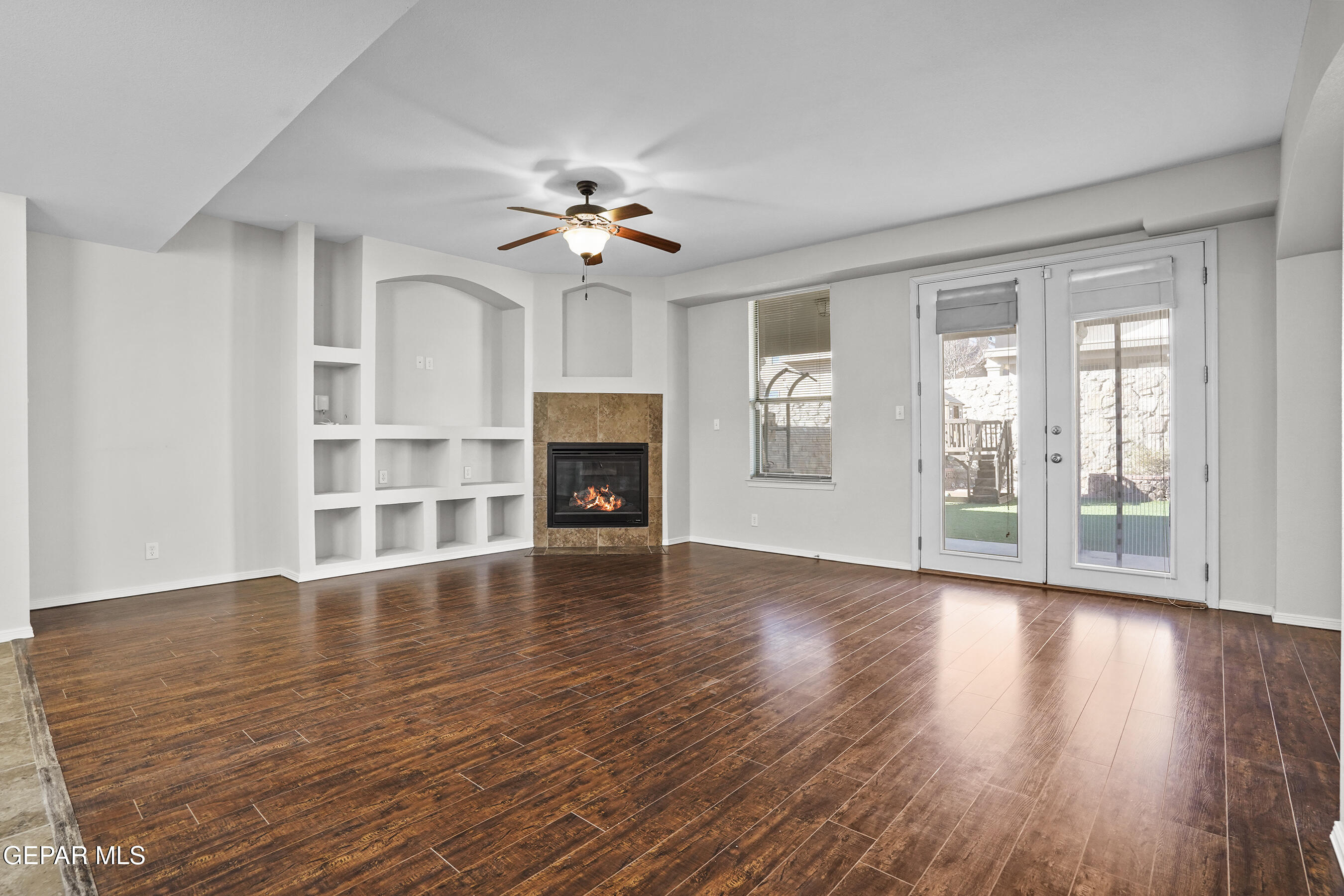 11265 Cattle Ranch Street El Paso, TX 79934 - Photo 2 of 44 a view of empty room with wooden floor and fireplace