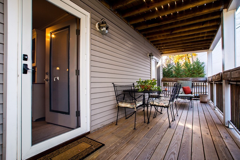 69 Parkton Road, Unit 1 Boston, MA 02130 - Photo 19 of 30 a view of a patio with table and chairs with wooden floor and fence