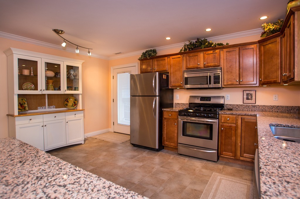 69 Parkton Road, Unit 1 Boston, MA 02130 - Photo 8 of 30 a kitchen with stainless steel appliances kitchen island granite countertop a refrigerator and a stove top oven
