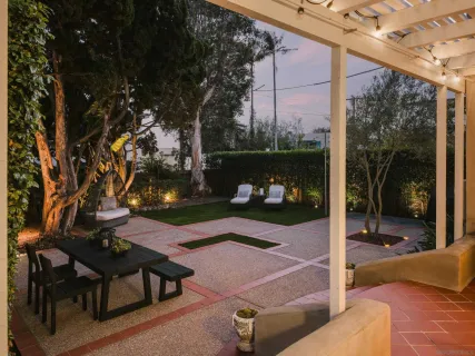 a patio with table and chairs and potted plants