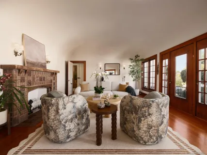 a living room with furniture a large window and wooden floor