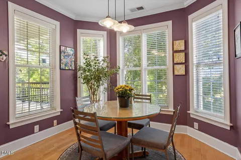 a dining room with furniture a chandelier and wooden floor