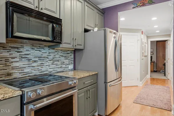 a kitchen with stainless steel appliances granite countertop a stove microwave and refrigerator