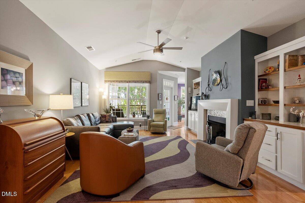 3700 Baron Cooper Pass, Unit 204 Raleigh, NC 27612 - Photo 9 of 39 a living room with furniture a fireplace and a large window