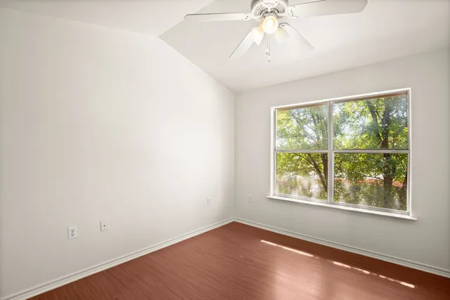 an empty room with a window and a ceiling fan