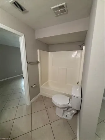 a bathroom with a granite countertop toilet and a shower