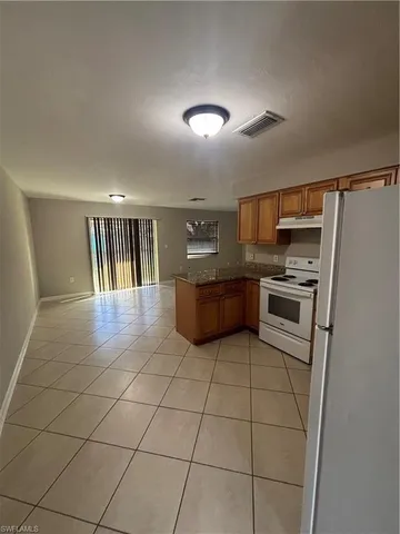 a kitchen with granite countertop a refrigerator and cabinets