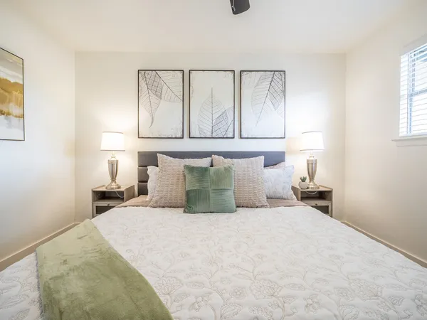a large bed sitting in a bedroom next to a window