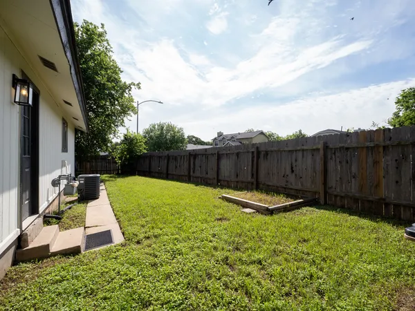 a view of a backyard with wooden fence