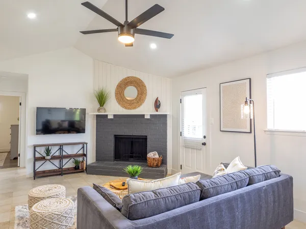 a living room with furniture a flat screen tv and a fireplace