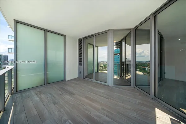 a view of an empty room with glass door and balcony