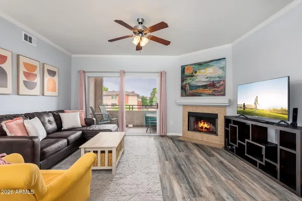 a living room with furniture a flat screen tv and a fireplace