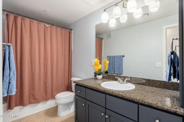a bathroom with a granite countertop sink toilet and mirror