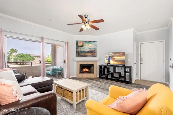 a living room with furniture a fireplace and a large window