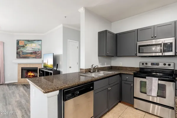 a kitchen with stainless steel appliances granite countertop a stove a sink and a microwave
