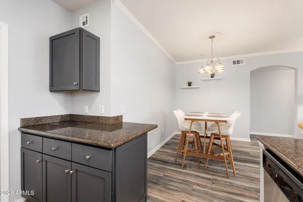 a kitchen with a table chairs and wooden floor