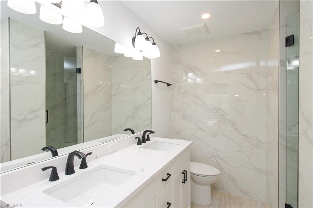 1435 Curlew Avenue, Unit 4 Naples, FL 34102 - Photo 11 of 26 a bathroom with a sink a toilet and shower