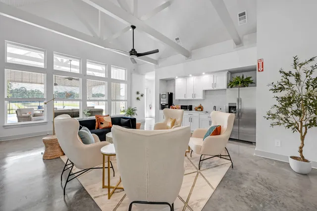 a living room with furniture a chandelier and a floor to ceiling window