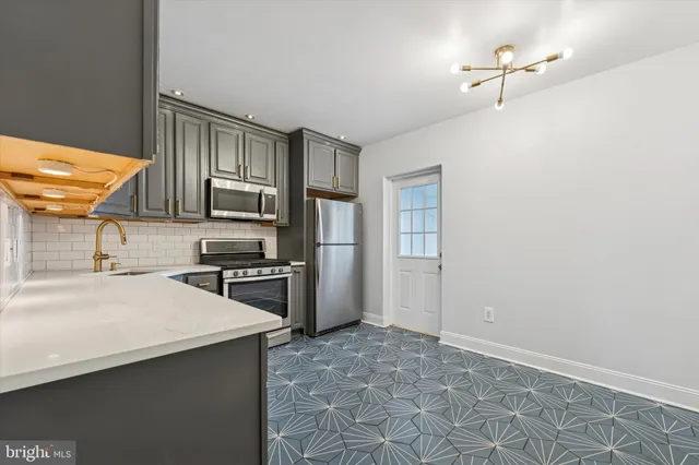 a kitchen with granite countertop a stove a sink and a refrigerator