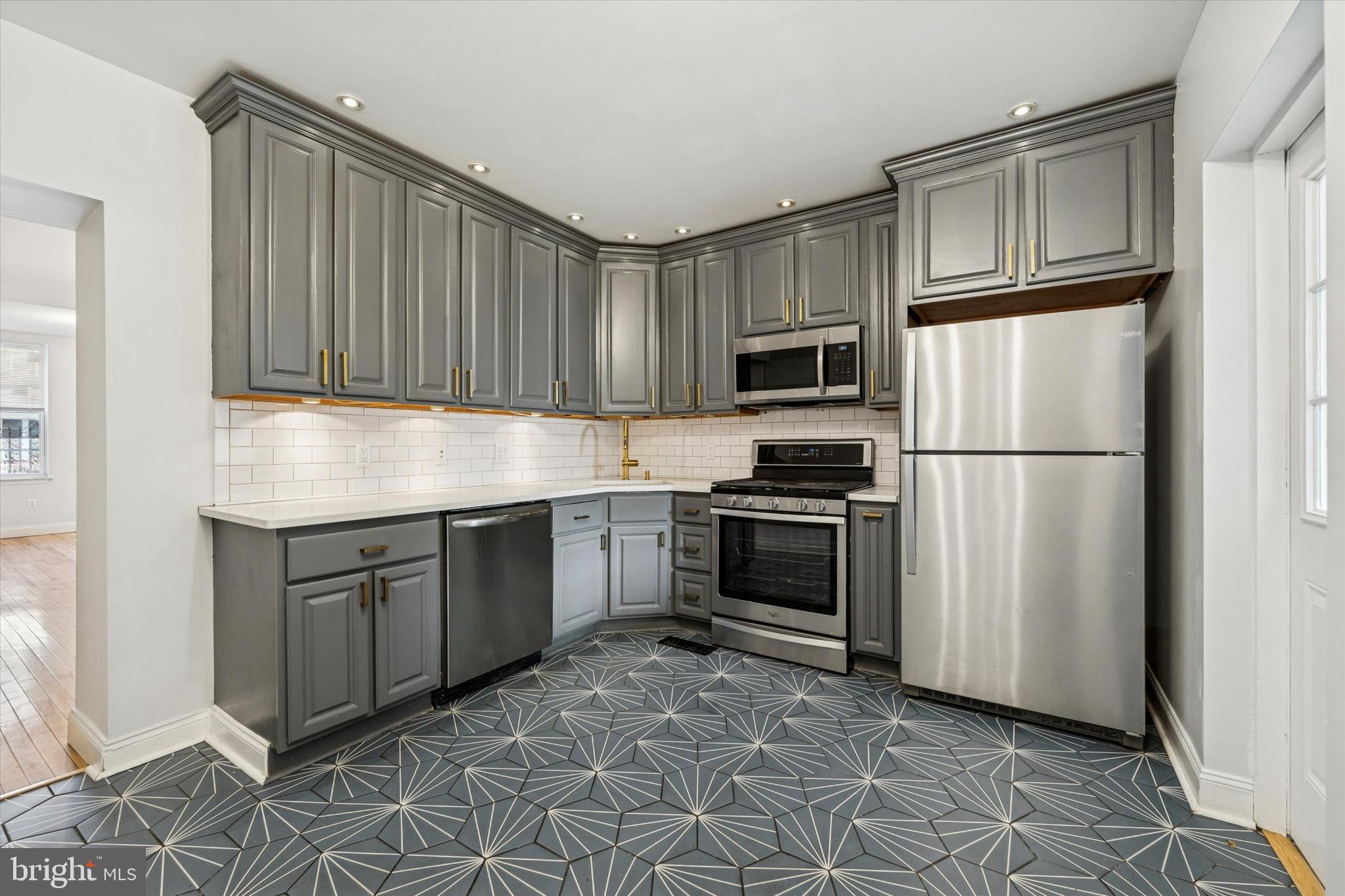 2814 West Stiles Street Philadelphia, PA 19121 - Photo 13 of 34 a kitchen with granite countertop a refrigerator stove top oven and sink