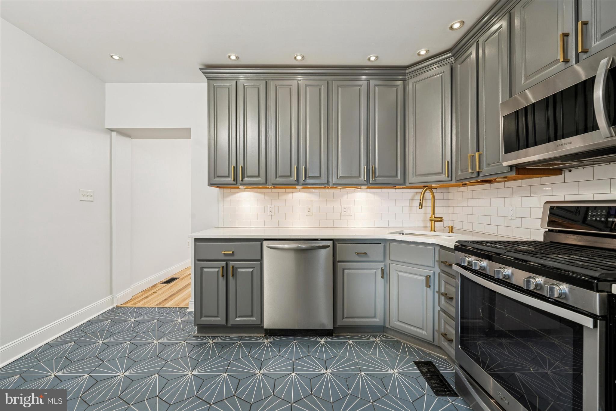 2814 West Stiles Street Philadelphia, PA 19121 - Photo 14 of 34 a kitchen with granite countertop a stove a sink and a microwave