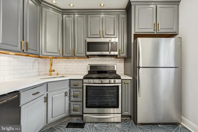 a kitchen with cabinets stainless steel appliances and a sink