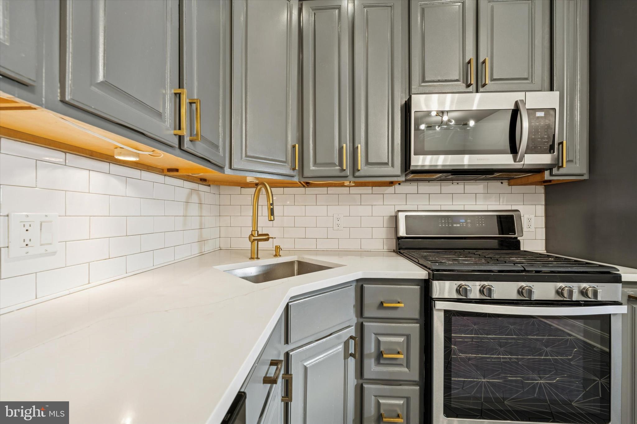 2814 West Stiles Street Philadelphia, PA 19121 - Photo 16 of 34 a kitchen with stainless steel appliances a stove a microwave and sink