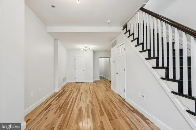 a view of a hallway with wooden floor and staircase