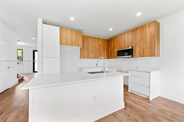 a kitchen with a sink appliances and cabinets
