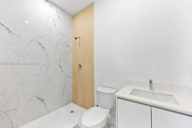 a white toilet sitting next to a bathroom sink